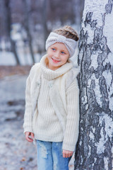 Portrait of cute beautiful girl in fur vest with bandage on head on spring day.