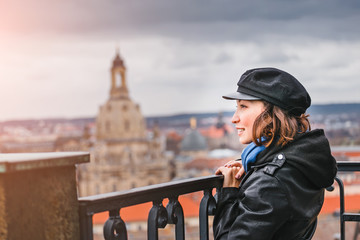 Happy woman travel in Europe, standing on the overlooking site against beautiful Dresden cityscape...