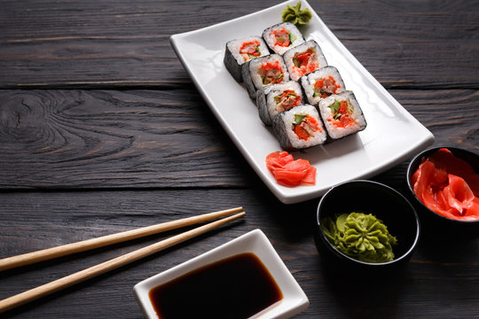 Set of sushi rolls on black wood background, closeup