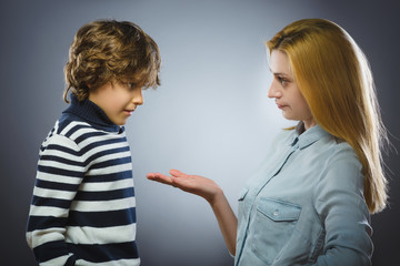 Woman scolding young boy. isolated over gray background