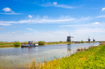 Fototapeta na wymiar Painting a bright beautiful landscape with boats and windmills in Kinderdijk, Netherlands, Europe.