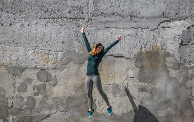 fitness girl in sport clothes on wall background