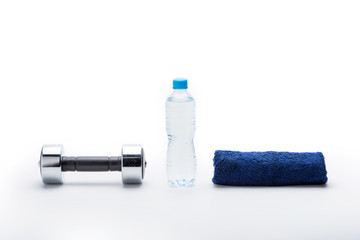 metallic dumbbell, towel and bottle with water isolated on white. equipment sport and healthy living concept