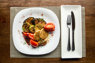 grilled vegetables with meat in a plate on a wooden table