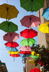 Multicolored umbrellas on street.