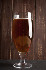 Lager beer in glass and potato chips on wooden background