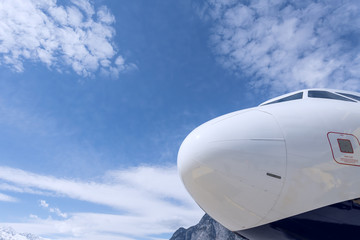Flugzeugnase vor blauem Himmel mit Wolken