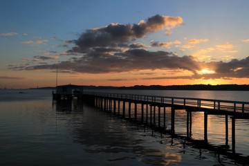 Fototapeta na wymiar Malerischer Bootssteg an der KIeler Förde bei Sonnenaufgang.