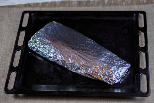 Fillet is fresher than fish wrapped in a foil on a black background
