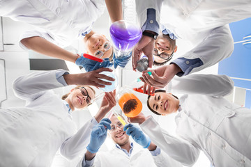 low angle view of scientists holding various test tubes - obrazy, fototapety, plakaty