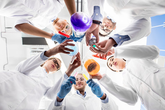 low angle view of scientists holding various test tubes