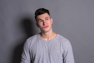 Fototapeta premium Facial expression, doubtful man looks up