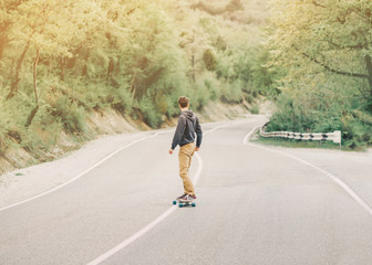 Man riding a longboard on mountain road © Alex Photo