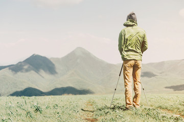 Explorer man with trekking poles in the mountains