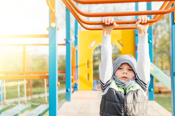 Obraz premium Little boy play on playground with blur park background