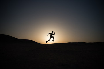 running man silhouette at sunset sky