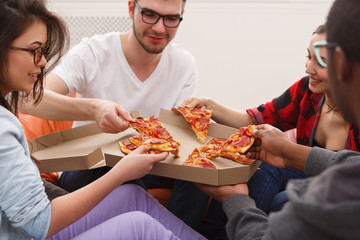 Students sharing pizza at home party