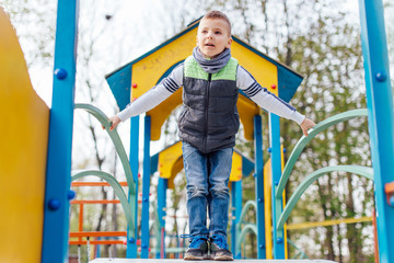Little boy play on playground with blur park background