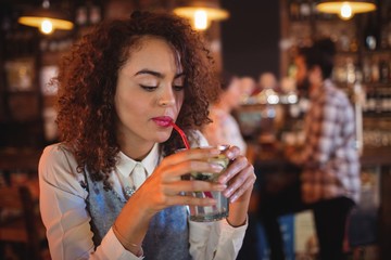 Young woman having red wine in pub