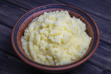 Mashed potatoes in a plate on the wooden table