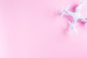 Photo of white quadrocopter on bright pink background