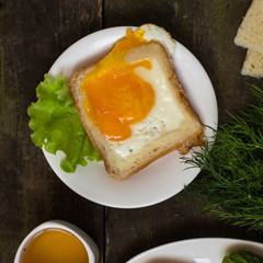 Fried eggs in bread and green lettuce leaf