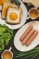 Sausages, scrambled eggs in bread, lettuce and greens - breakfast