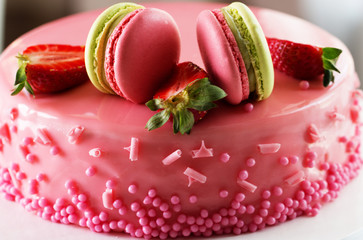 Pink romantic cake decorated with macaroons and strawberry