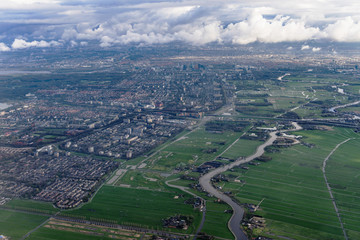 Beautiful view through airplane window, airplane flying above city.