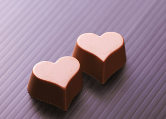 Close-up of chocolates with heart shape on black background.