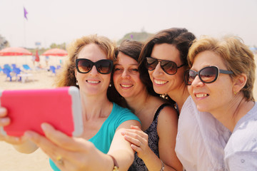 Portrait of four smiling 40 years old women outdoors