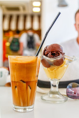 Cold coffee frappe with ice cream in the glass bowl in cafe
