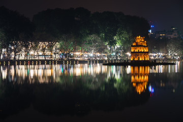 Night view of the Turtle Tower or Tortoise Tower reflection in Hoan Kiem Lake (Lake of the Returned Sword) at historic centre of Hanoi, Vietnam. The tower is located on an island in the middle of Lake