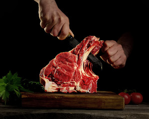 Man cutting raw beef meat.