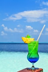 Glass of drink is on a beach table