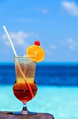 Glass of drink is on a beach table