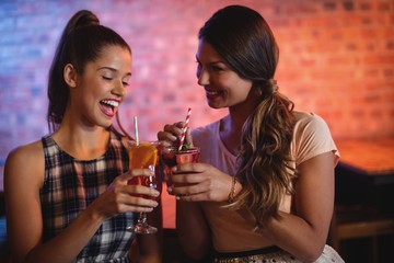 Two young women having cocktail drinks