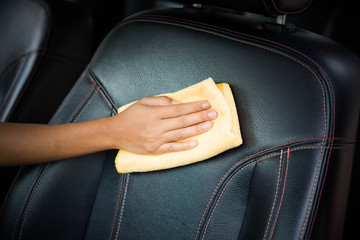 A Man Worker Cleaning Seat Inside The Car