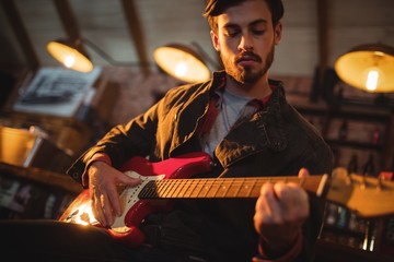 Young man playing guitar  - Powered by Adobe