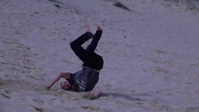 Boy Performs a somersault on the beach, slow motion