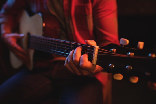 Mid-section of man playing guitar 