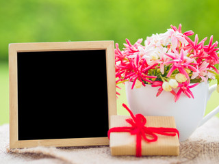 Poster mock up template with flower bouquet, marshmallow in the shape of heart and gift over green background