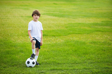 Boy with a soccer ball on a soccer field.