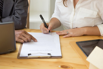 Person's hand hold ballpoint pen writing on  agreement paper sheet, fill in document template, applying for mortgage loan