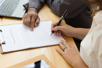 Person's hand hold ballpoint pen writing on  agreement paper sheet, fill in document template,...