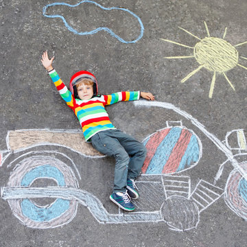 Little child in helmet with motorcycle picture drawing with colo