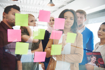 Business people putting ideas on adhesive notes