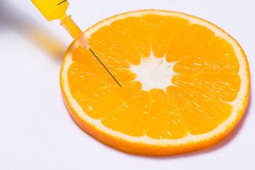 Science experiment with orange and syringe isolated on white.