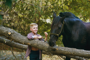 the boy on the ranch next to his horse