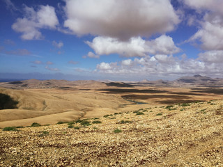 Beautiful view overlooking rusty red desert, distant mountains in Fuerteventura island, Canaries, Spain